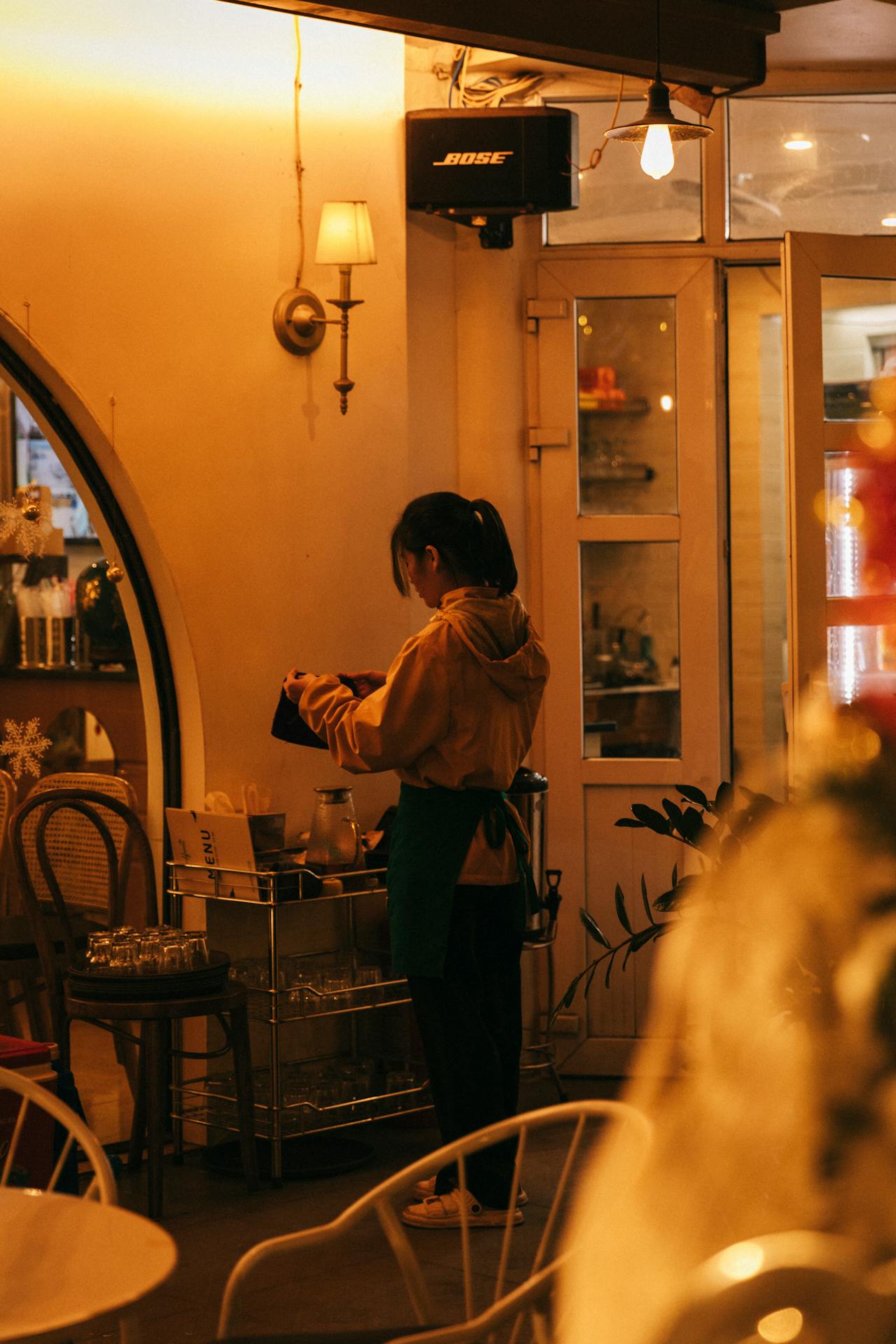 Kellnerin nimmt Bestellung am Tablet-Kassensystem auf in warmem Caf&eacute;